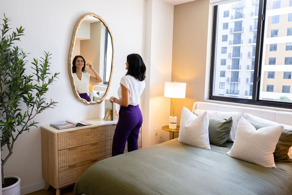 Resident in styled bedroom with city view at Metro Parc Hialeah
